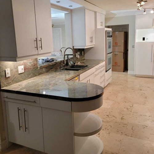 White painted kitchen cabinets with a granite island